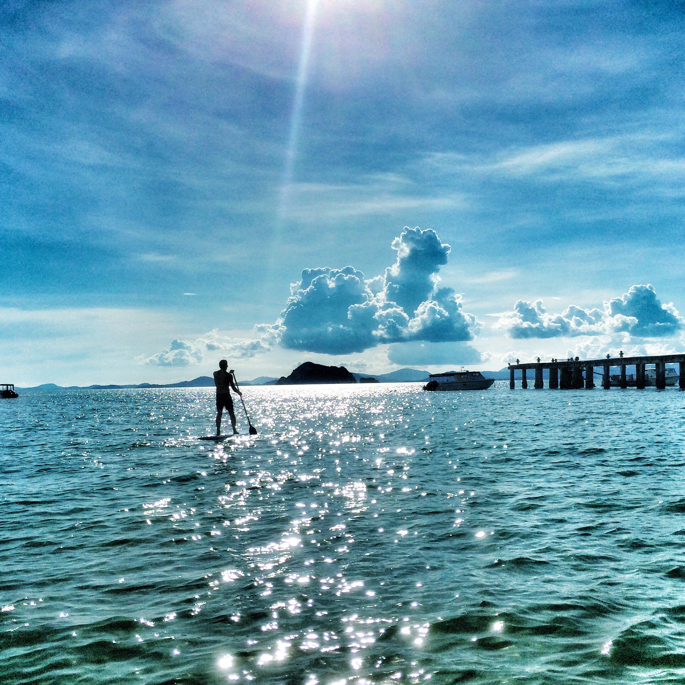 rear-view-silhouette-man-paddleboarding-sea