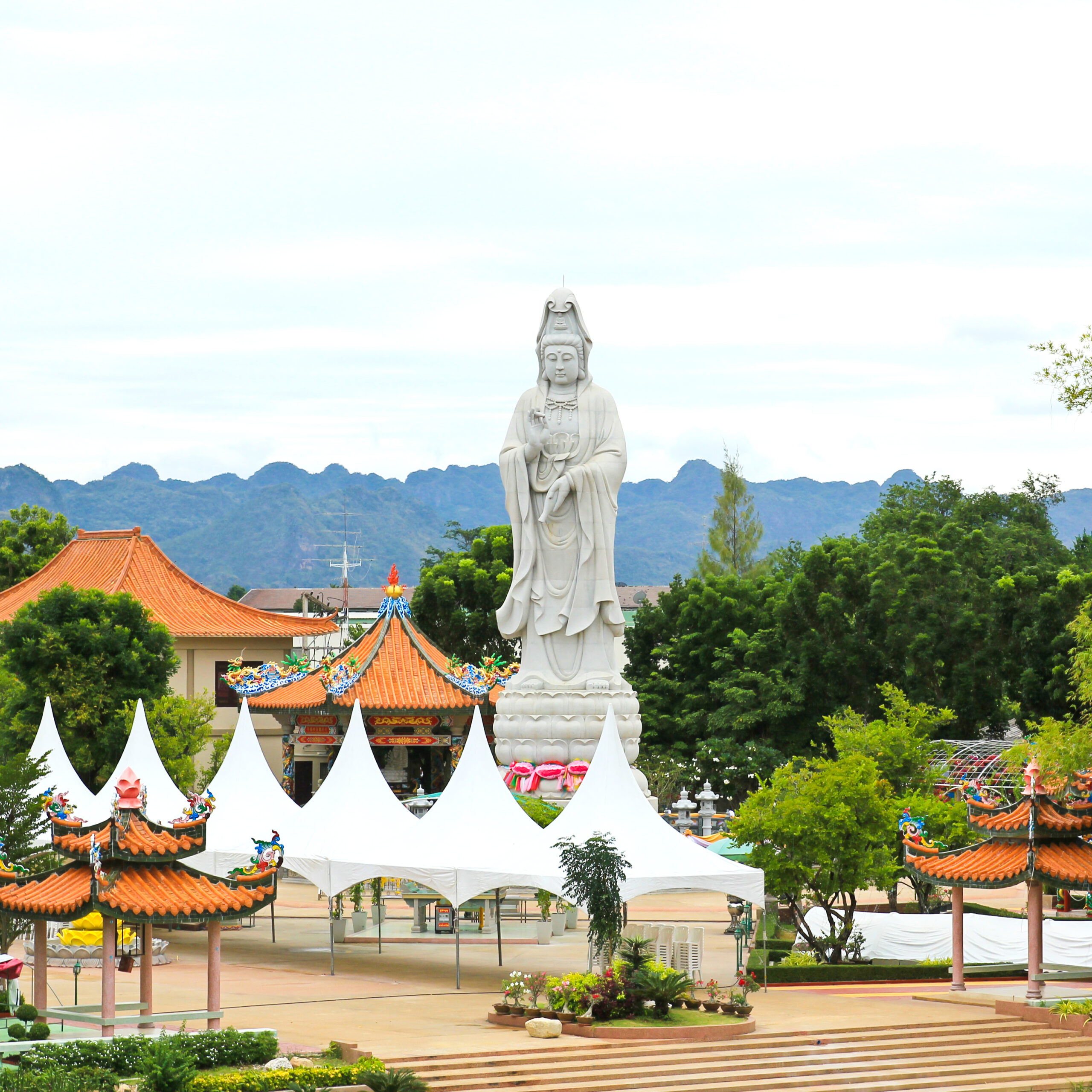 White marble Quan Yin stand near The Bridge of the River Kwai ,Kanchanaburi ,Thailand.
